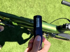 A handheld digital scale reading the weight of the Batch GB.1 gravel bike, with the bike visible below.
